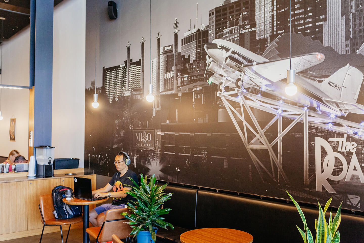 Image of a man on a laptop working at a table inside The Roasterie Café Leawood Kansas location.
