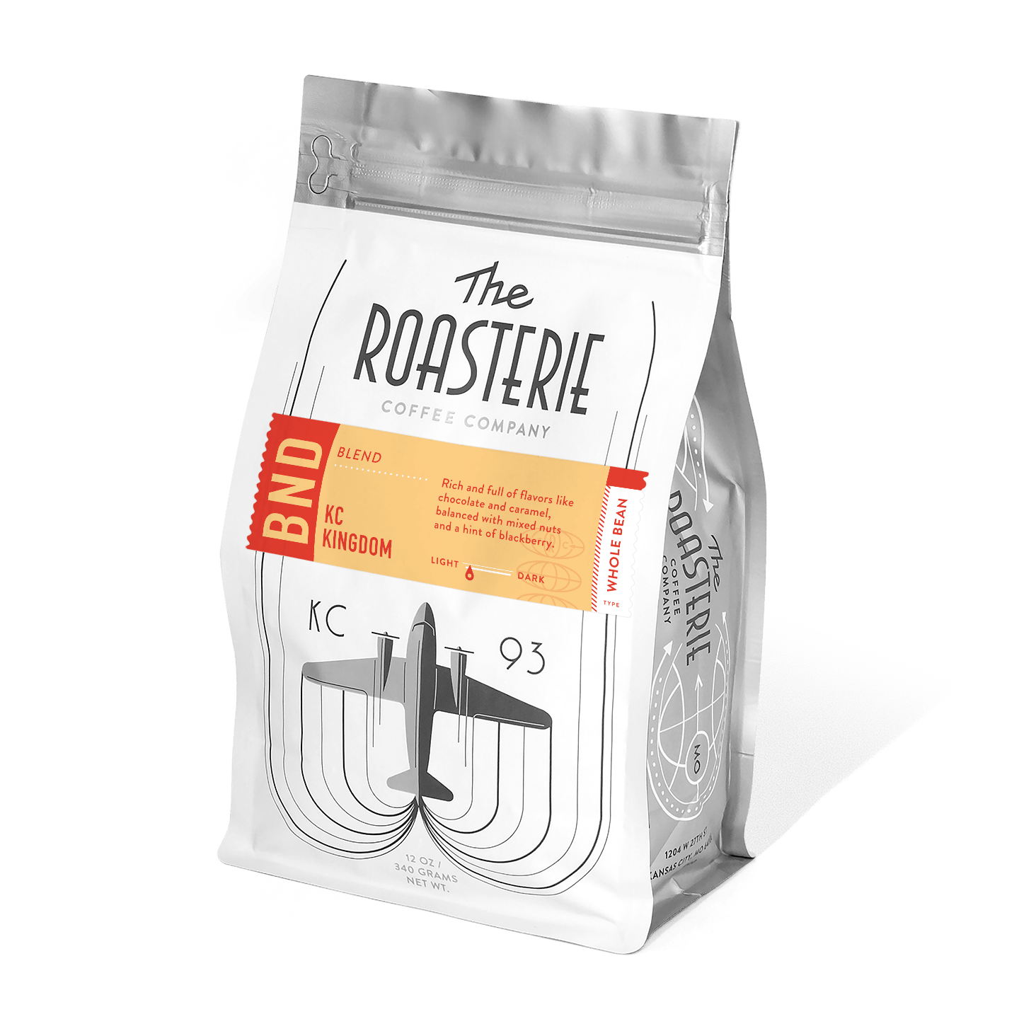 KC Kingdom Blend coffee bag from The Roasterie featuring distinctive airplane design on white packaging, with orange accent label showcasing rich blend of chocolate, caramel, and mixed nuts with blackberry notes