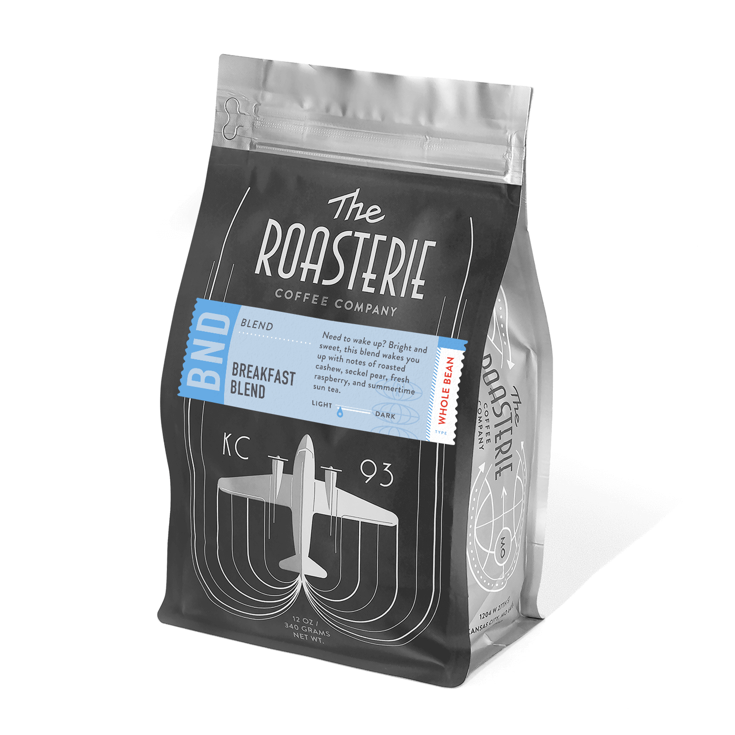 A bag of Breakfast Blend coffee from The Roasterie featuring an art deco airplane design in silver on black packaging with blue accent label, offering bright and sweet morning coffee with notes of roasted cashew, pear, and raspberry