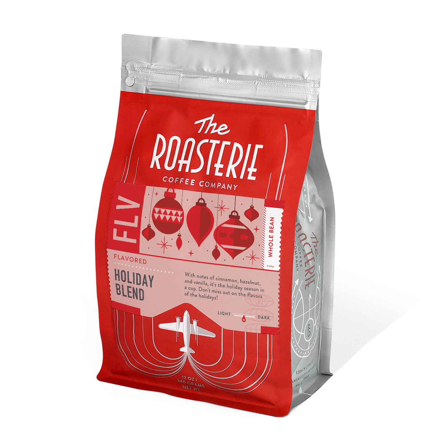 The Roasterie Holiday Blend coffee bag in red and silver featuring vintage-style ornament designs and an airplane logo, showcasing a festive seasonal coffee blend with cinnamon, hazelnut, and vanilla flavors